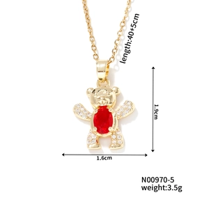 Detail view of gold bear pendant with red gemstone and dimensions 1.9cm by 1.6cm