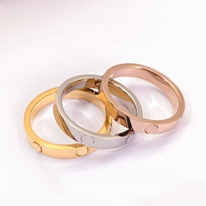 Macro shot of interlocking titanium steel rings with screw motifs in gold, silver, and rose gold