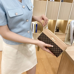 Women long brown patterned wallet with cream trim and gold zipper shown in lifestyle setting