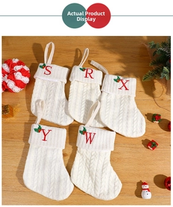 Detailed knit white Christmas stocking with red embroidered letters and holly ornaments