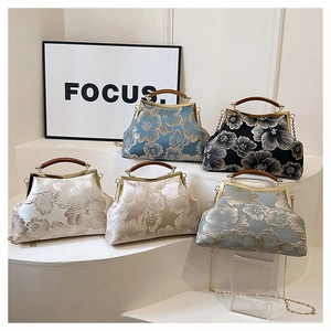 Detailed display of vintage satin handbags with floral embroidery and wooden handles