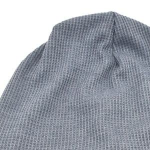 Macro shot of gray waffle knit fabric texture on a soft slouchy beanie hat