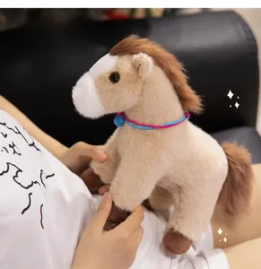 Detailed view of a plush horse toy with brown mane and blue bell being held by a model