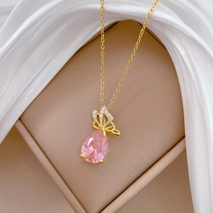 Elegant gold butterfly necklace with pink teardrop crystal on white silk background