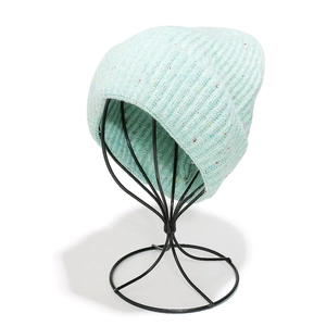 Détail d'un bonnet en maille côtelée vert menthe avec mouchetures colorées sur support