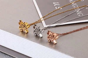 Detailed view of Tree of Life pendants in gold, silver, and rose gold stainless steel