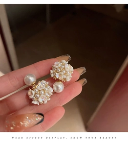 Detail shot of vintage flower pearl stud earring with golden base and cluster design