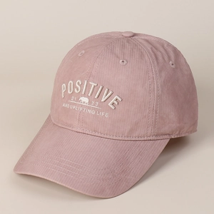 Détail de casquette rose avec broderie Positive blanche et motif ours sur visière courbée