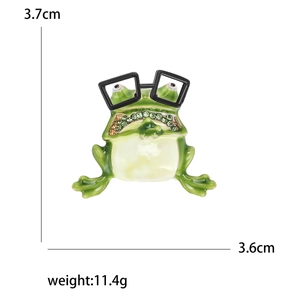Funny green frog brooch with black glasses and sparkling green rhinestones on white background