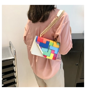 Crossbody bag with colorful geometric Tetris-style pattern and gold chain strap on model