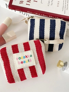 Striped canvas makeup pouch in red and blue with herringbone texture and zipper