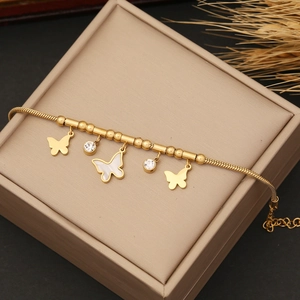 Gold butterfly snake chain bracelet with pearl shell and zircon charms on jewelry box