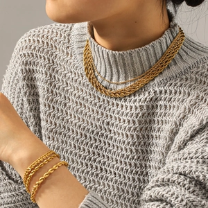 Detail of 18k gold plated stainless steel twisted chain necklace and bracelet on a model
