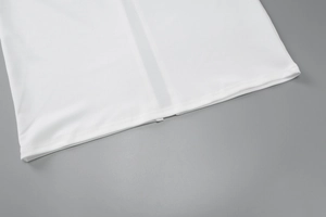 Détail rapproché de la texture du tissu blanc et coutures de qualité sur l'ourlet de robe