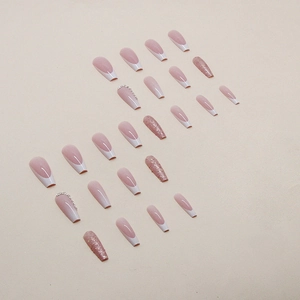 French gradient press-on nails in nude pink with white tips and glitter accents
