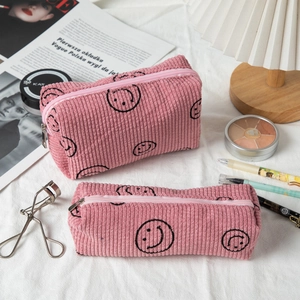 Pink corduroy makeup bags with smiley prints shown in a lifestyle setting