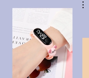 Close-up of pink children's LED watch with cartoon character and silicone strap