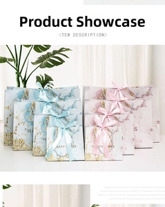 Detail of marble pattern gift bags in blue and pink with satin ribbons and gold accents