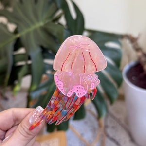 Detailed view of jellyfish hair claw clip with pink marble acetate and colorful tentacles