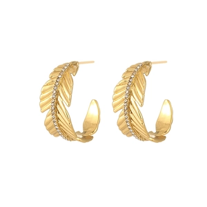 Macro shot of gold leaf feather earrings featuring delicate micro-set zircon stones