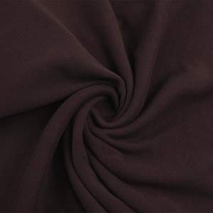 Texture détaillée d'un tissu en maille café foncé montrant les fibres et le drapé doux