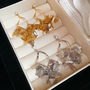 Elegant gold and silver leaf tassel earrings with sparkling cubic zirconia on velvet