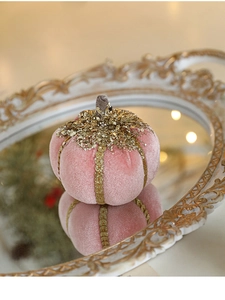 Detail of pink velvet pumpkin with gold sequins on a mirrored tray for festive decor