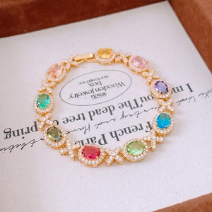 Dettaglio delle pietre ovali multicolore e connettori X in zircone nel bracciale oro