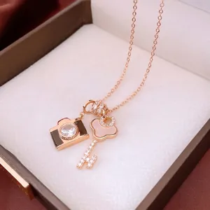 Rose gold adjustable necklace with cubic zirconia camera and mother-of-pearl key pendants