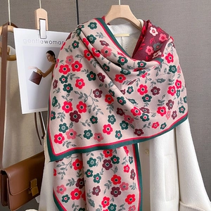 Detail view of vintage floral scarf in beige with red and green patterns on a hanger