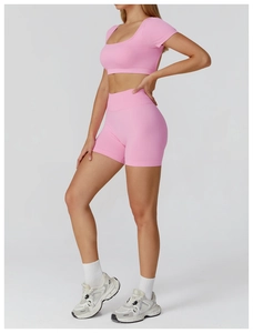 Detail view of pink seamless ribbed yoga set featuring short sleeve crop top and shorts