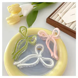 Close-up of jelly-colored bow hair claws in green, pink, and white on a tray