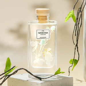 Reed diffuser set with preserved white flowers and essential oils in a clear glass bottle