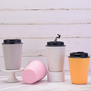 Eco-friendly wheat straw coffee cups in grey, pink, beige, and orange on marble surface