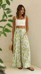 Detail of high-waist wide-leg pants with pineapple and palm leaf print and elastic waist