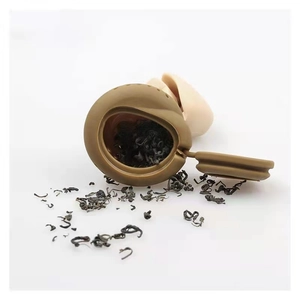 Detailed view of creative silicone poop tea infuser filled with loose leaf tea leaves
