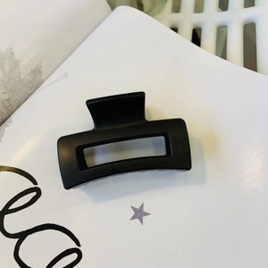 Close-up of black matte rectangular hollow hair claw clip showing frosted texture
