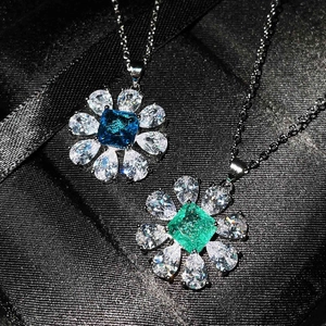 Macro detail of floral pendants with sky blue and green square-cut center gemstones