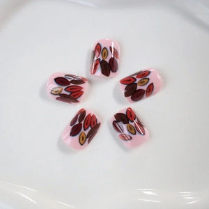 Short square press-on nails with autumn leaf patterns on a soft pink base