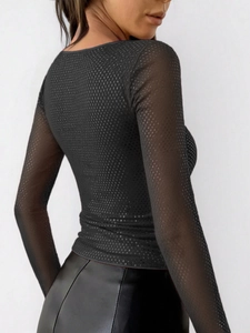 Vista posteriore del top nero Y2K in mesh trasparente con texture a pois fini