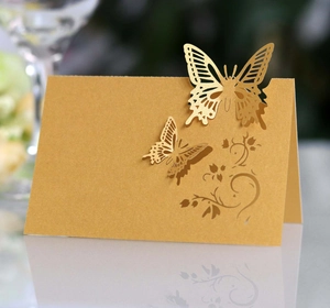 Close-up of golden 3D laser-cut butterfly place card with elegant hollow pattern
