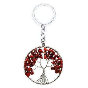 Detailed close-up of a silver Tree of Life keychain with red natural crystal stone leaves