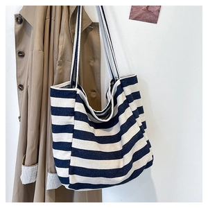 Detail of a large capacity navy blue striped canvas tote bag in a casual lifestyle setting