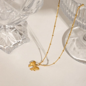 Elegant gold stainless steel bow pendant necklace with a delicate bead chain on white background