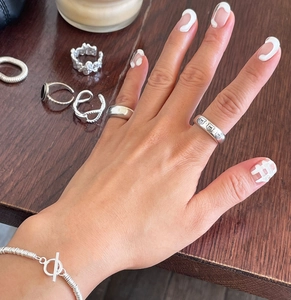 Detail shot of minimalist S925 sterling silver bear ring and beaded bracelet on hand