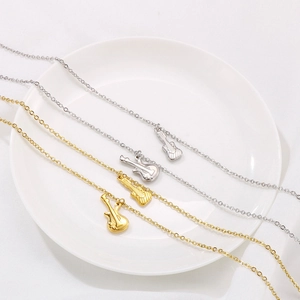 Collier avec pendentif violon guitare en finition or et argent sur plateau blanc
