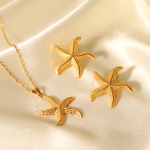 Ensemble élégant collier et boucles d'oreilles étoile de mer dorée sur soie beige