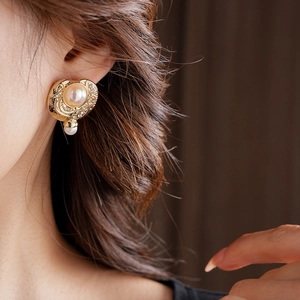 Gros plan d'un mannequin portant des boucles d'oreilles vintage en perles et diamants