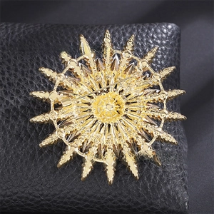 Macro shot of the gold snowflake brooch back showing the safety pin and metal texture