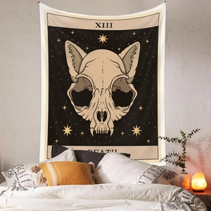 Detail of bohemian tarot cat skull tapestry on white wall in cozy bedroom setting